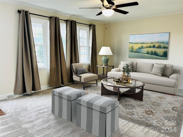 carpeted living room featuring ornamental molding, ceiling fan, and a healthy amount of sunlight