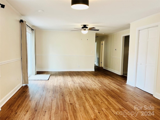 spare room featuring wood-type flooring, ceiling fan, and crown molding