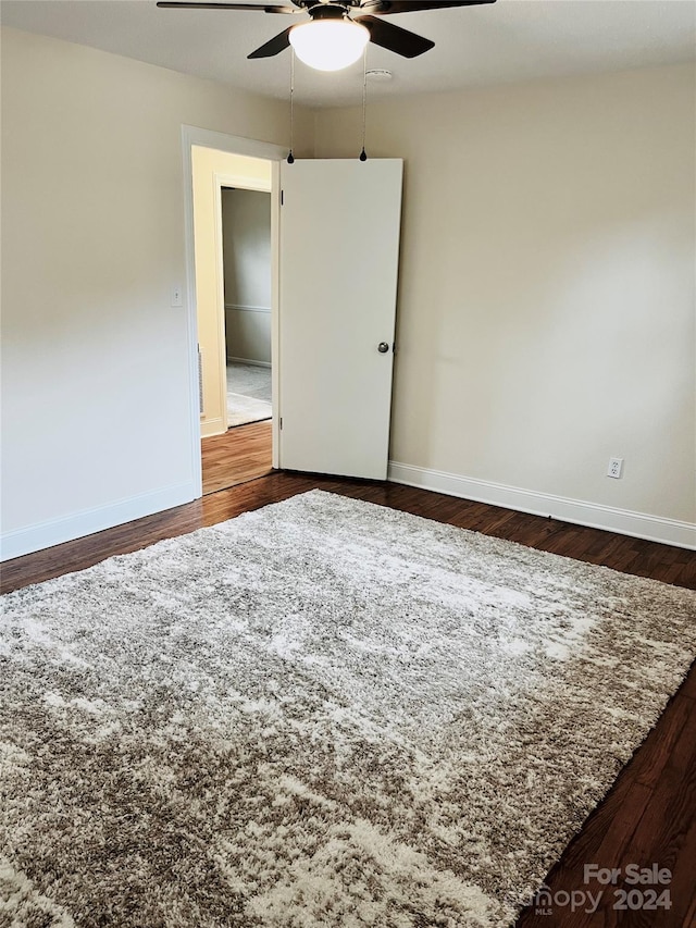 spare room with dark hardwood / wood-style floors and ceiling fan