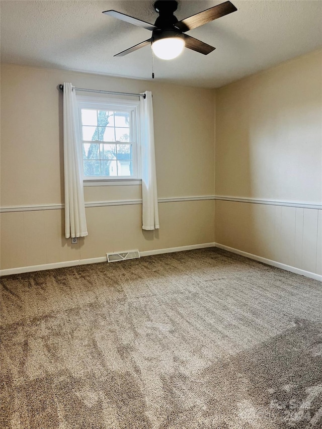 unfurnished room featuring ceiling fan, carpet, and a textured ceiling