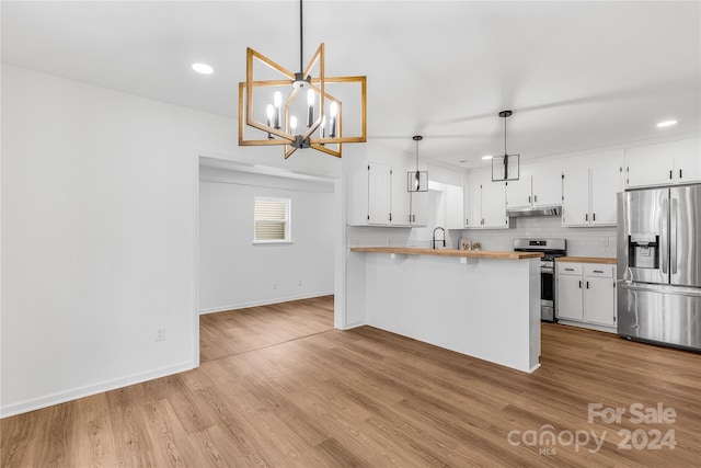 kitchen featuring wood counters, stainless steel appliances, white cabinets, light hardwood / wood-style floors, and hanging light fixtures