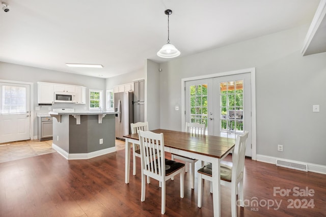 dining space featuring wood-type flooring and french doors