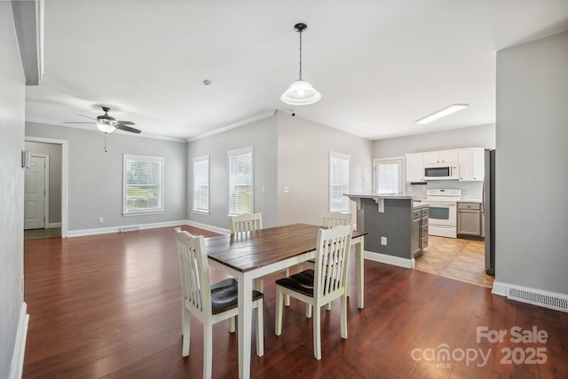 dining area with crown molding, dark hardwood / wood-style floors, and ceiling fan