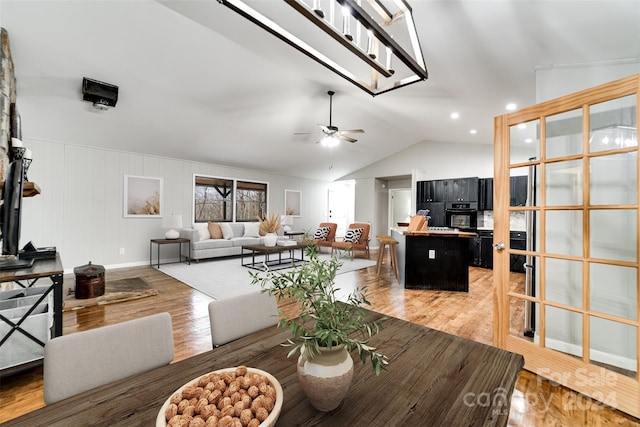 dining room with ceiling fan, light hardwood / wood-style flooring, and lofted ceiling