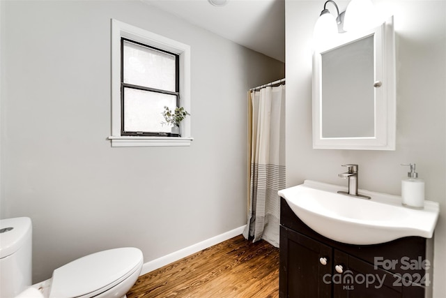 bathroom featuring wood-type flooring, vanity, and toilet