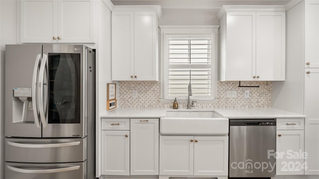 kitchen with appliances with stainless steel finishes, white cabinetry, and sink