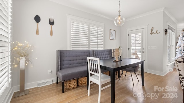 dining space with crown molding and hardwood / wood-style floors