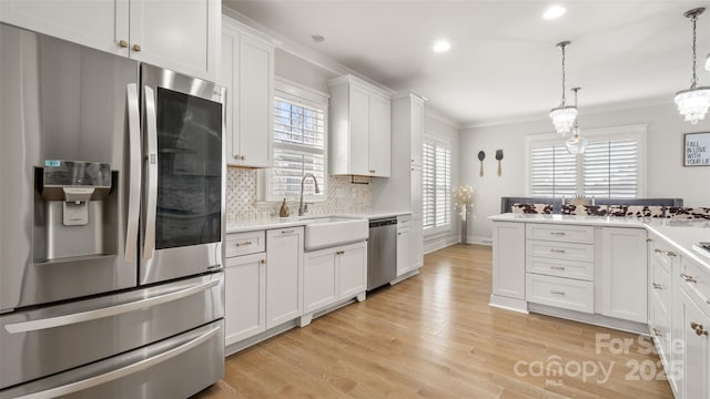 kitchen with pendant lighting, white cabinetry, backsplash, stainless steel appliances, and light hardwood / wood-style floors