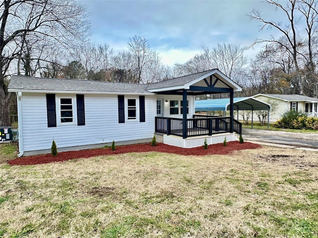 view of front of property with a front yard and a carport