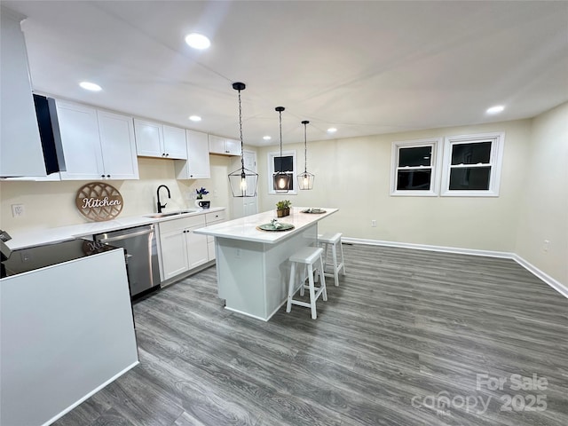 kitchen with pendant lighting, a center island, sink, stainless steel dishwasher, and white cabinetry