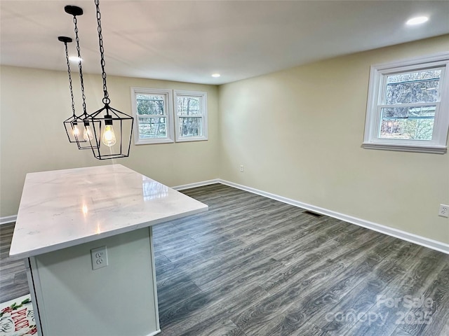 interior space featuring a center island, pendant lighting, and dark hardwood / wood-style floors