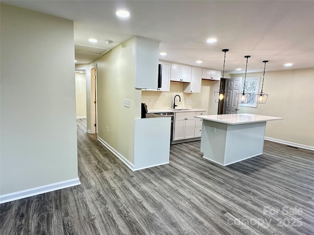 kitchen featuring white cabinets, a kitchen island, dark wood-type flooring, and sink