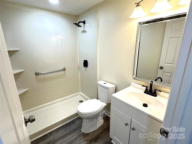 bathroom with hardwood / wood-style floors, vanity, toilet, and walk in shower