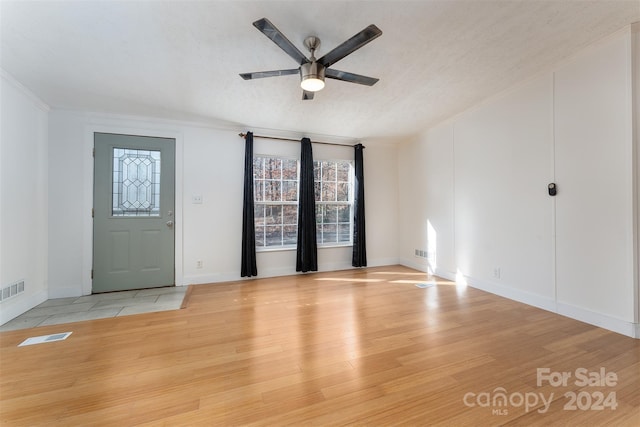 interior space with ceiling fan, light hardwood / wood-style floors, crown molding, and a textured ceiling