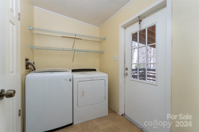 laundry area with crown molding, separate washer and dryer, and a textured ceiling