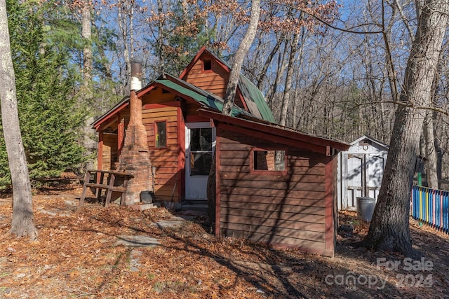 view of side of home with a storage shed