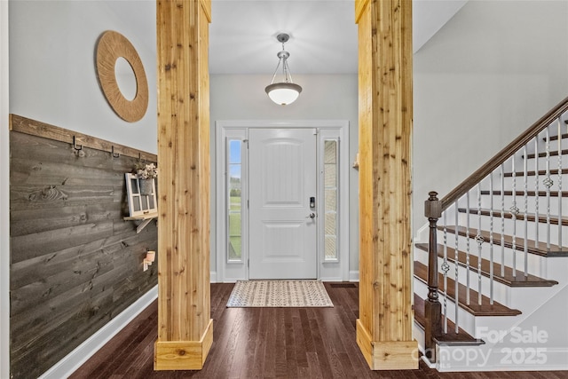 entrance foyer with wooden walls and dark wood-type flooring