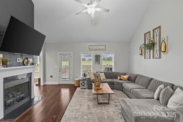 living room featuring ceiling fan, dark hardwood / wood-style flooring, and vaulted ceiling