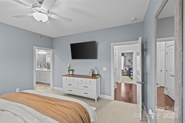 bedroom with ceiling fan, light carpet, and connected bathroom