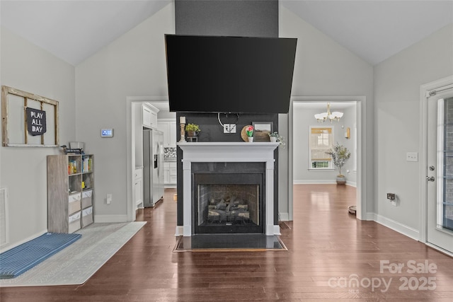 living room featuring hardwood / wood-style flooring, vaulted ceiling, and a chandelier