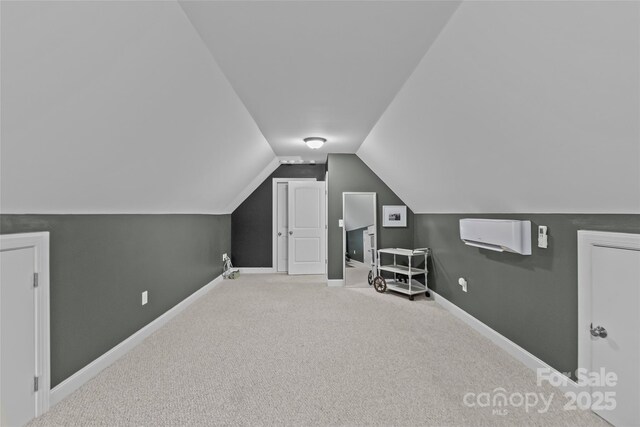 additional living space featuring carpet and vaulted ceiling