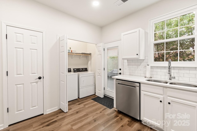 kitchen with white cabinetry, dishwasher, sink, backsplash, and washer and dryer