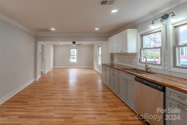 kitchen with butcher block countertops, dishwasher, white cabinetry, and light hardwood / wood-style flooring