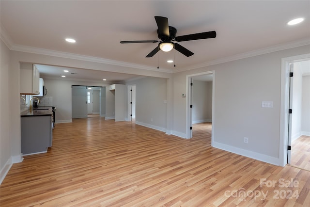 unfurnished living room featuring ceiling fan, light hardwood / wood-style floors, and ornamental molding