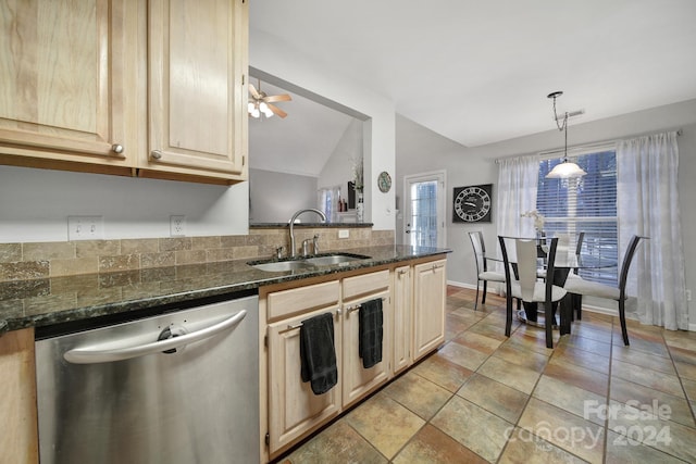 kitchen with ceiling fan, sink, stainless steel dishwasher, dark stone counters, and vaulted ceiling