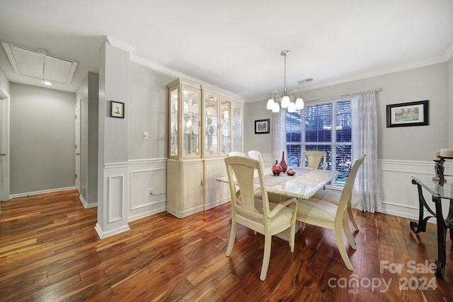 dining room featuring dark hardwood / wood-style floors, crown molding, and an inviting chandelier