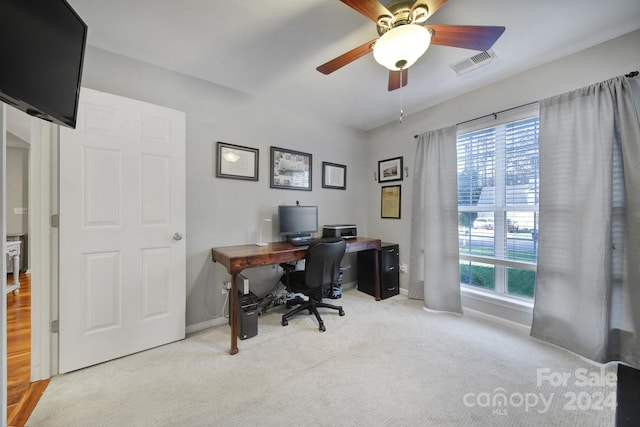 office space with a wealth of natural light, ceiling fan, and light carpet