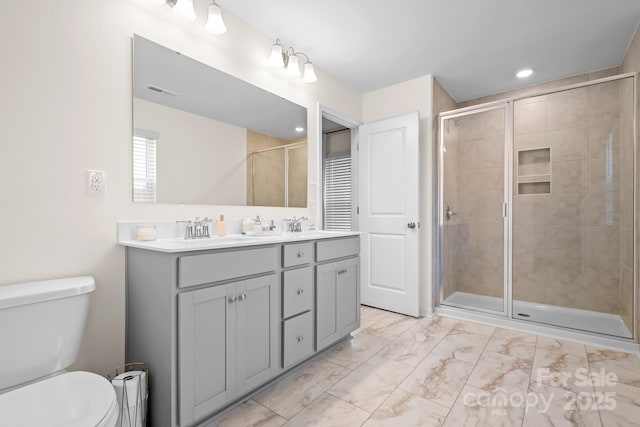 bathroom with vanity, toilet, and a shower with door