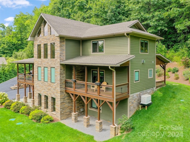 rear view of property with a wooden deck and a yard