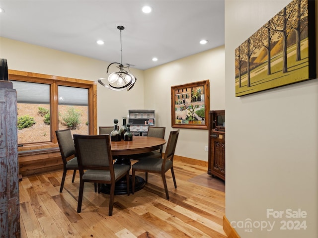 dining space with an inviting chandelier and light hardwood / wood-style flooring