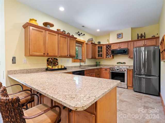 kitchen with a kitchen breakfast bar, sink, light stone countertops, kitchen peninsula, and stainless steel appliances