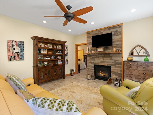 living room with ceiling fan and a fireplace