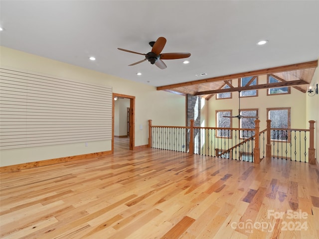 spare room with vaulted ceiling with beams, ceiling fan, and light hardwood / wood-style flooring