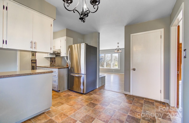 kitchen featuring an inviting chandelier, white cabinets, hanging light fixtures, and appliances with stainless steel finishes