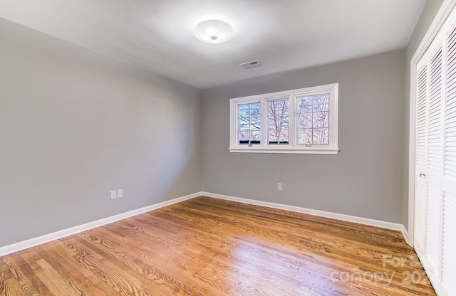 unfurnished bedroom featuring hardwood / wood-style floors and a closet