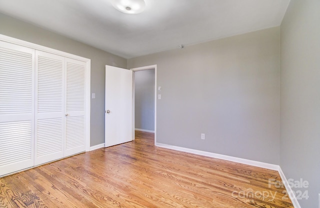 unfurnished bedroom featuring a closet and light wood-type flooring