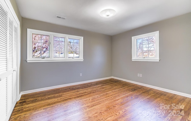 unfurnished bedroom with a closet and dark hardwood / wood-style flooring