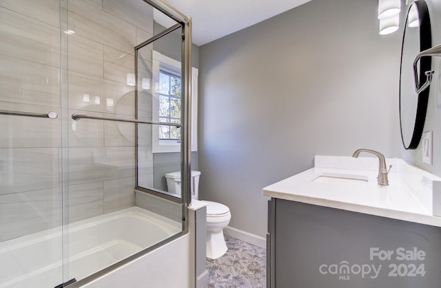 full bathroom featuring tile patterned floors, vanity, bath / shower combo with glass door, and toilet