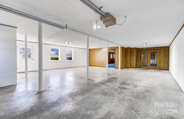 garage with wood walls and a garage door opener