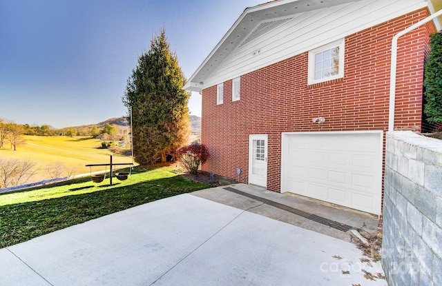 view of property exterior featuring a lawn and a garage