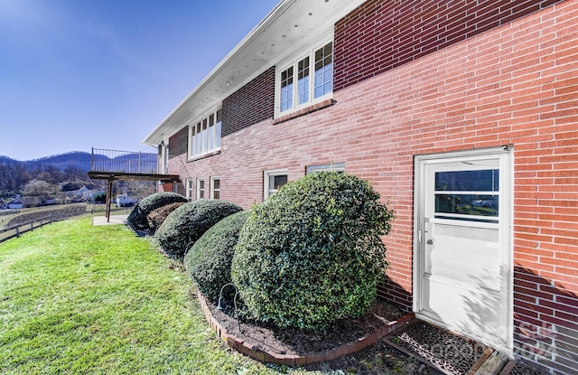 view of home's exterior with a mountain view and a yard