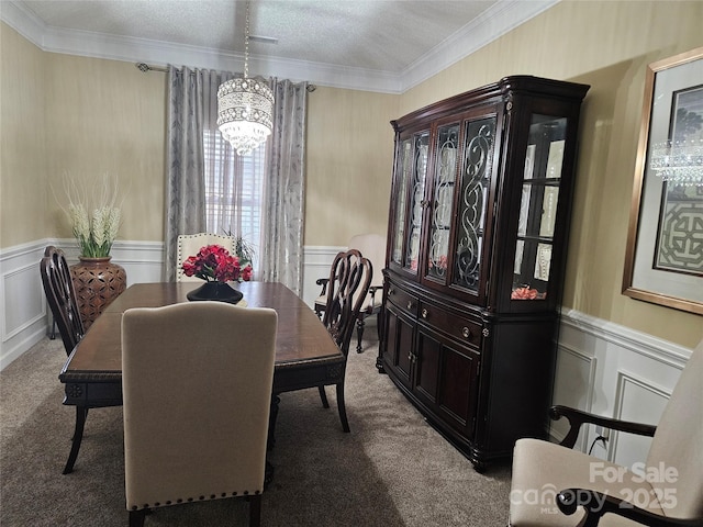 carpeted dining space with ornamental molding and an inviting chandelier