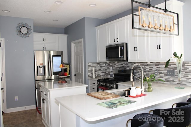 kitchen with appliances with stainless steel finishes, decorative light fixtures, tasteful backsplash, white cabinetry, and a center island