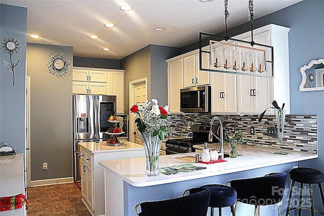 kitchen featuring stainless steel appliances, a kitchen bar, kitchen peninsula, and hanging light fixtures