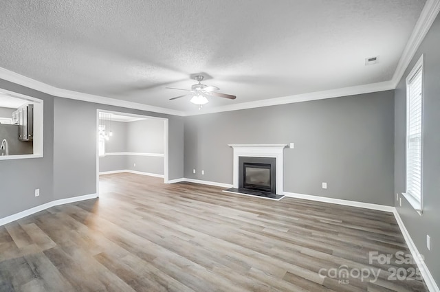 unfurnished living room featuring a textured ceiling, light wood-type flooring, and crown molding