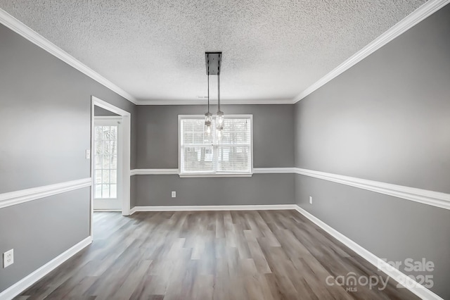 unfurnished dining area with ornamental molding, plenty of natural light, and a notable chandelier